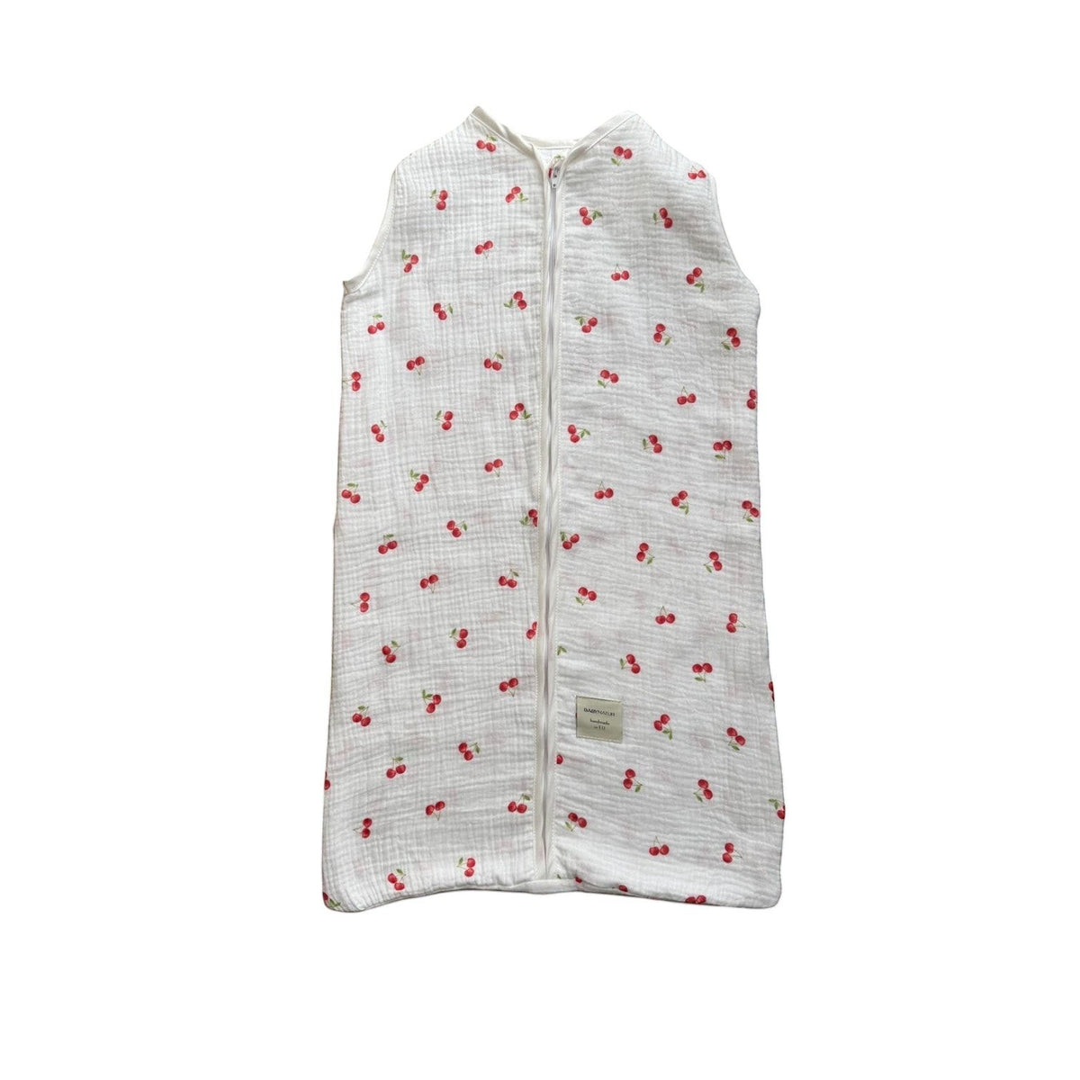 Baby Natur sleeveless sleeping bag with a white background and red cherry print. Made from soft, breathable cotton.