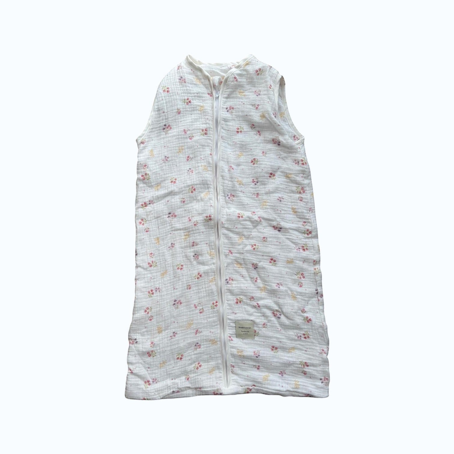 Baby Natur sleeveless sleeping bag with a delicate floral print in pink and yellow on white muslin fabric. Zipper closure.