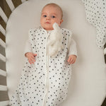 Baby Natur white sleeveless sleeping bag with black polka dots, made of soft, breathable cotton. Features a zipper closure.