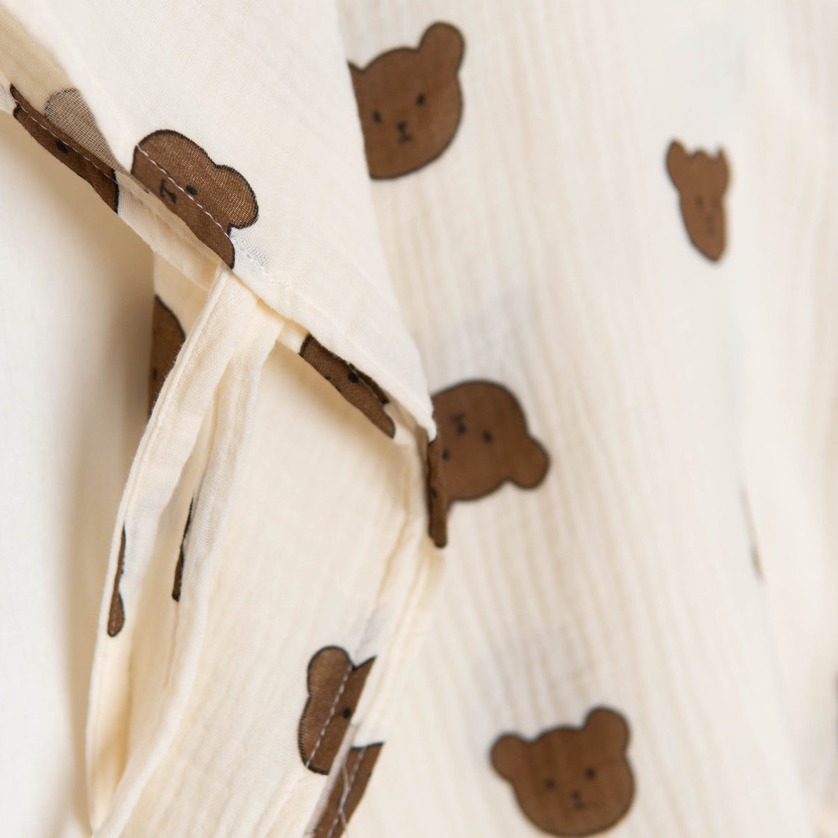 Baby Natur muslin poncho with a cute brown bear print on a cream background. Soft and breathable fabric.