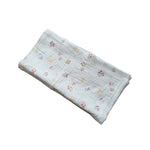 Baby NaturStandard tetra diaper made of 100% cotton with a delicate floral print in pink, purple, and yellow.