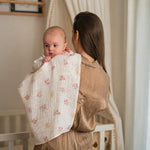 Baby NaturHere standard tetra diaper made of 100% cotton with a floral print, draped over a mother's shoulder.